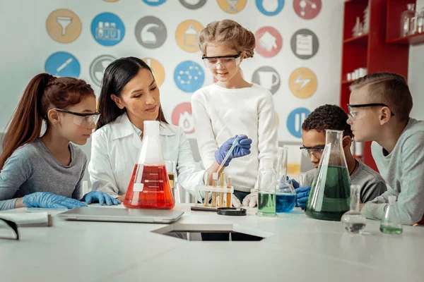 Glada brunett kvinna arbeta i laboratoriet för tonåringar — Stockfoto