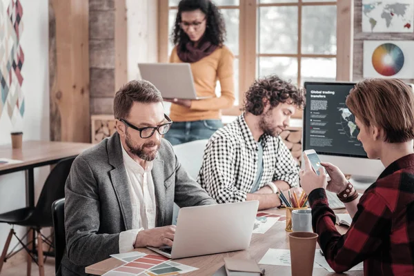 Koncentrerad skäggiga arbetare som stirrade på sin dator — Stockfoto