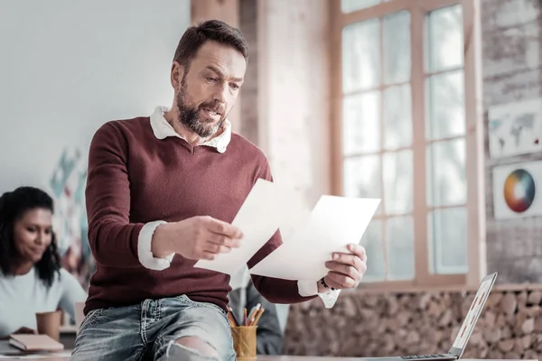 Hombre serio comprobando la información en sus notas — Foto de Stock