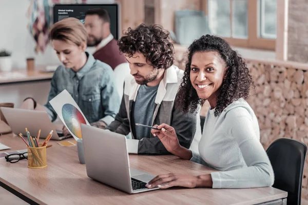 Vrij internationale meisje zit in de buurt van haar collega 's — Stockfoto