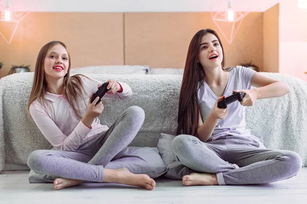 Chicas alegres usando consolas para jugar — Foto de Stock