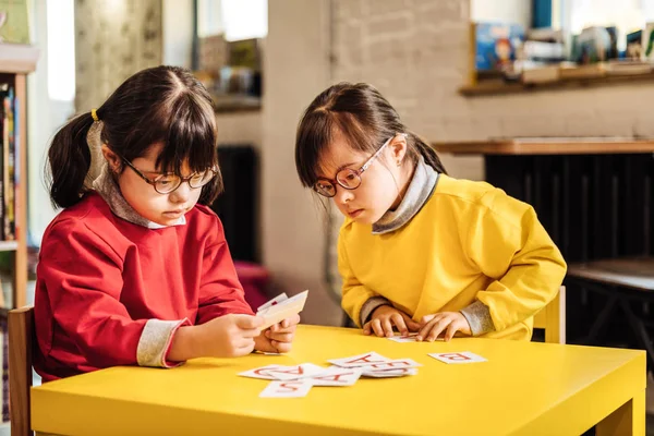 Dos niños soleados que se sienten involucrados en el aprendizaje de tarjetas — Foto de Stock