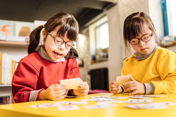 Sisters with Down syndrome playing with cards together — Stock Photo, Image