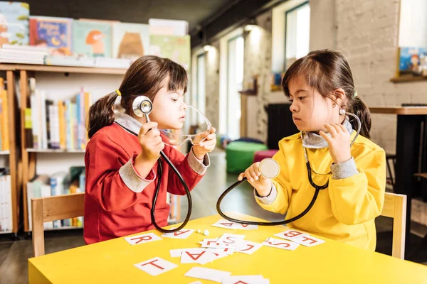 Two sunny children pretending to be doctors playing in kindergarten — Stock Photo, Image