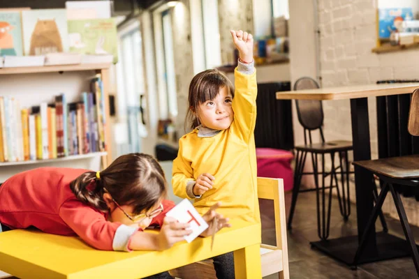 Enfant ensoleillé aux yeux foncés levant la main tout en se sentant heureux — Photo