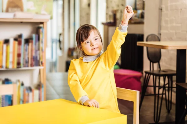 Enfant ensoleillé portant un pull jaune assis à la maternelle — Photo