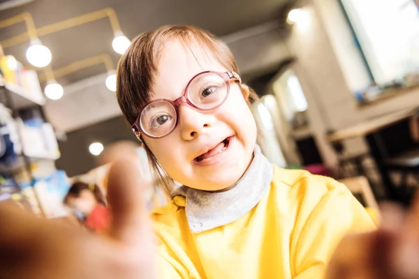 Close up van meisje met syndroom van Down dragen van helder gele trui — Stockfoto