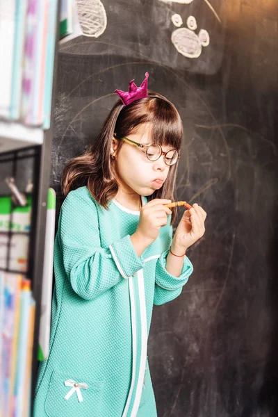 Grappige donker-eyed zonnige kind dragen van bril en kleine kroon — Stockfoto