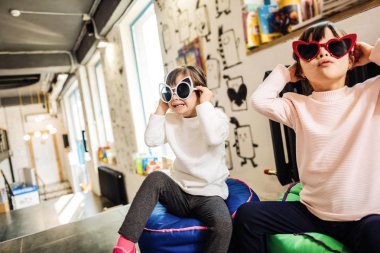 Kazak kız. Tozluk ve birbirine yakın oturan ışık kazak giyen iki esmer kız kardeş