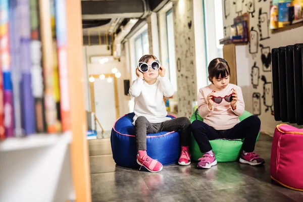 Piacevole soleggiato bambini che tengono divertenti occhiali da sole luminosi — Foto Stock