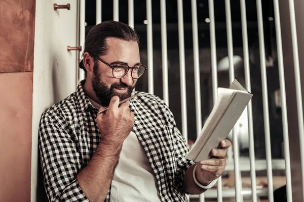 Netter nachdenklicher Mann studiert sorgfältig seine Notizen — Stockfoto