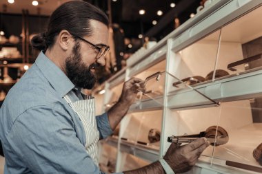 Bir taze kruvasan alarak memnun iyi adam