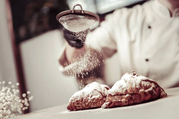 Sugar powder being put on two croissants — Stock Photo, Image