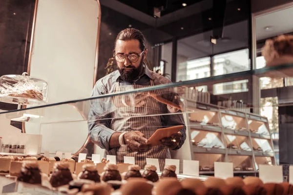 Komoly férfi cukrász sütemények minőségi ellenőrzése — Stock Fotó