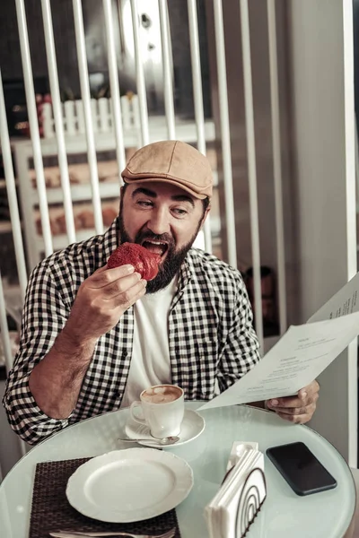 Hombre guapo positivo sosteniendo un menú — Foto de Stock