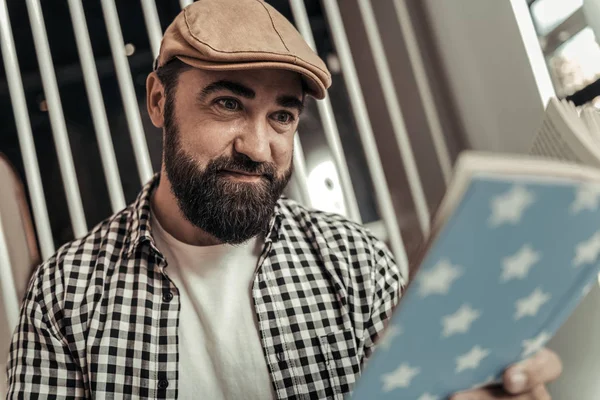 Радостный бородатый мужчина читает книгу — стоковое фото