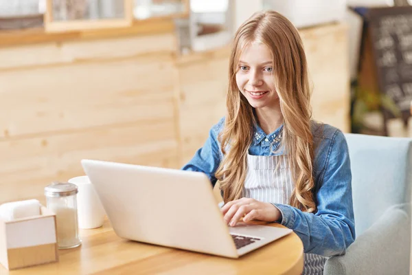 Mosolygó fiatal hölgy használ a laptop a kávézóban — Stock Fotó