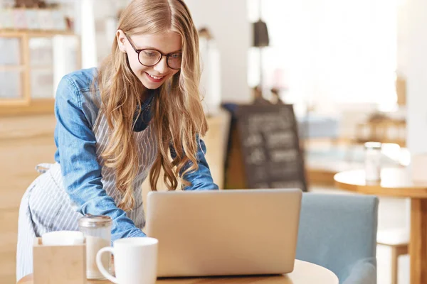 Vrolijk meisje werken in café schort dragen — Stockfoto