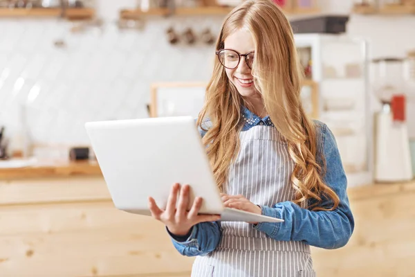 Stralende jonge dame met laptop in café — Stockfoto