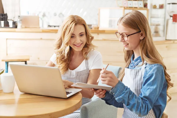 Hija pensativa ayudando a la madre en la cafetería — Foto de Stock