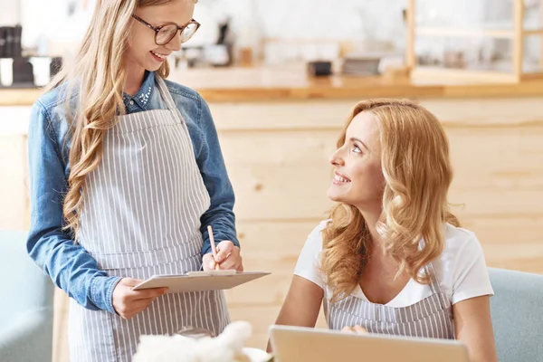 Adorable child taking order from mom in family cafe