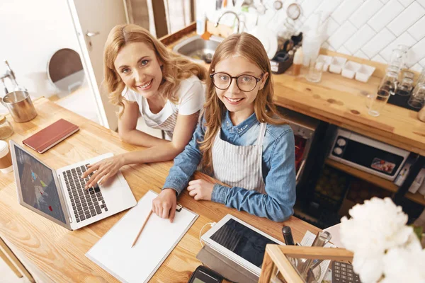 Linda madre e hija trabajando en el escritorio del cajero en la cafetería — Foto de Stock