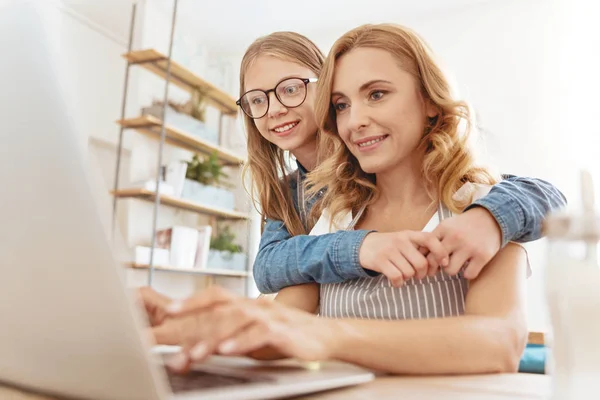 Kíváncsi lánya, anyja dolgozik laptop csatlakozás — Stock Fotó