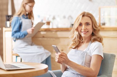 Kameraya bakarak telefon ile sakin gülümseyen kadın