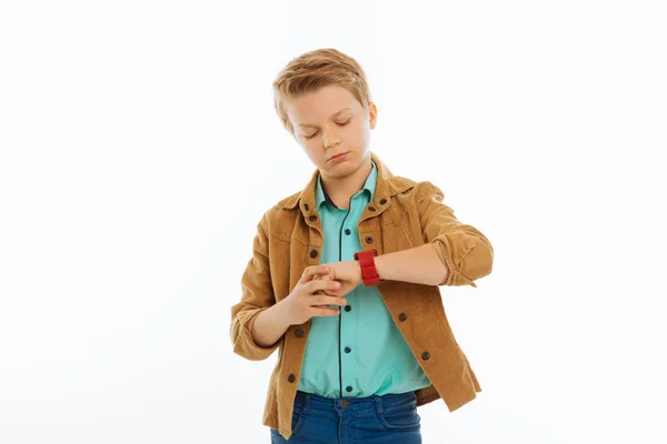 Grave ragazzo fiducioso guardando il suo orologio — Foto Stock