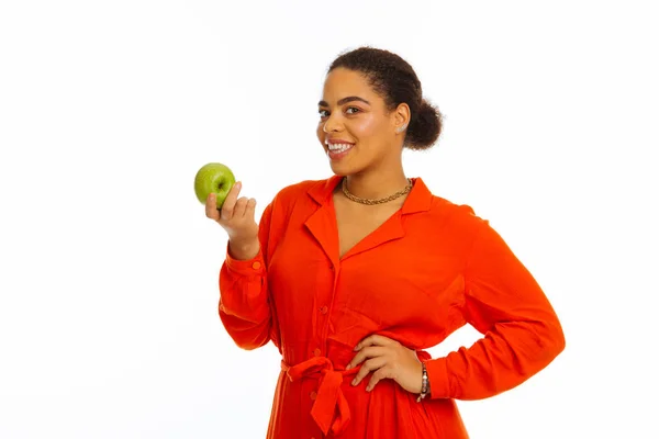 Радостная пухлая позитивная женщина держит яблоко — стоковое фото