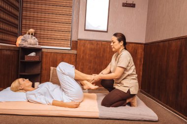 İstemciler bacaklarını birlikte koyarak güzel yetenekli kadın