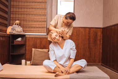 Minderin üzerine oturan memnun genç kadın