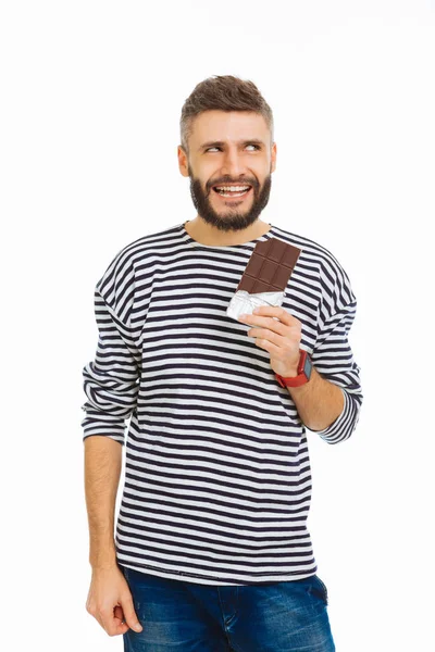 Positivo bell'uomo godendo la sua barretta di cioccolato — Foto Stock