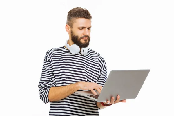 Серьезный молодой человек смотрит на экран своего ноутбука — стоковое фото