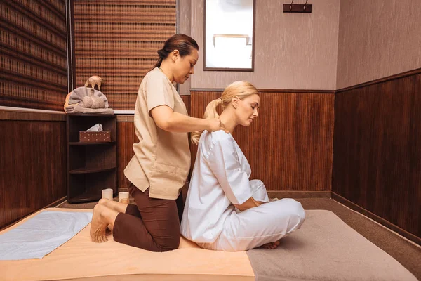Hermosa mujer rubia disfrutando de su masaje en el hombro — Foto de Stock