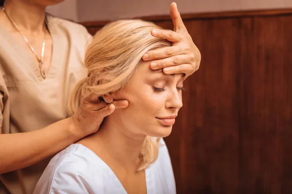 Ansikte av en avslappnad ung kvinna med massage — Stockfoto