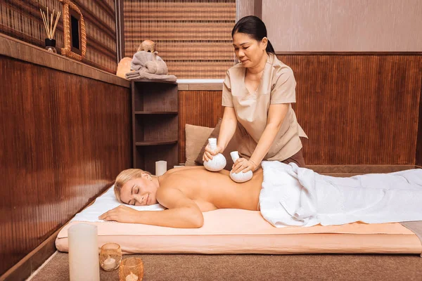 Professionale asiatico massaggiatrice holding speciale bianco bags — Foto Stock