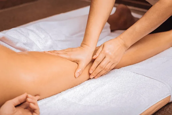 Professionele vrouwelijke masseuse aanraken van haar klanten-been — Stockfoto