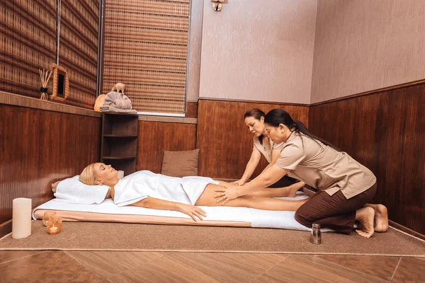 Profesionální masážní terapeuti dělají olejová masáž — Stock fotografie