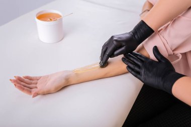 Profesyonel depilatory master müvekkili kolunda balmumu koymak