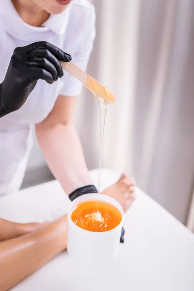 Professionell hårborttagning master sätta vax på benen på hennes klient — Stockfoto