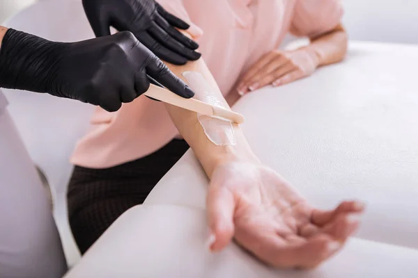 Businesswoman wearing beige blouse having depilation of arms — Stock Photo, Image