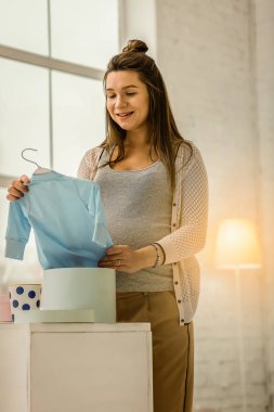 Hamile kadın giysileri onun gelecekteki bebek için hazırlanıyor