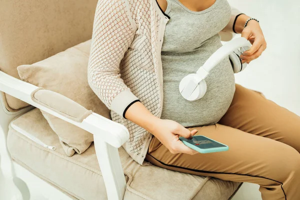 Mulher grávida usando uma música para se comunicar com o futuro bebê — Fotografia de Stock