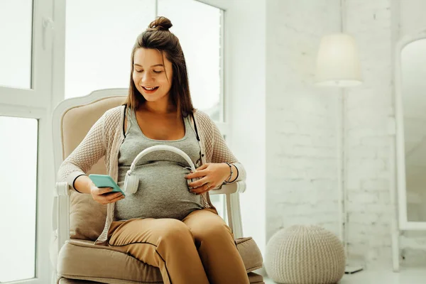 Mujer embarazada comunicándose con su futuro bebé usando la música — Foto de Stock