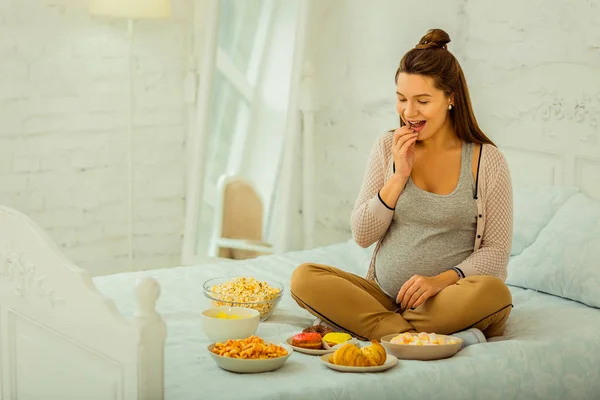 Mujer embarazada eligiendo una comida para comer — Foto de Stock