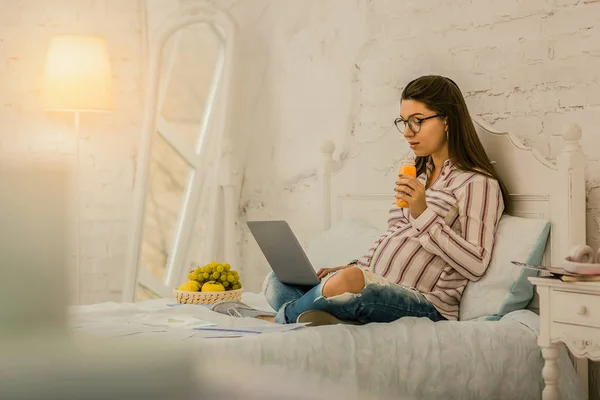 Skoncentrowane w ciąży kobieta pracuje zdalnie w domu — Zdjęcie stockowe