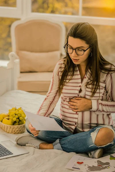 Gravid kvinna noggrant läsa arbetsdokumentet — Stockfoto