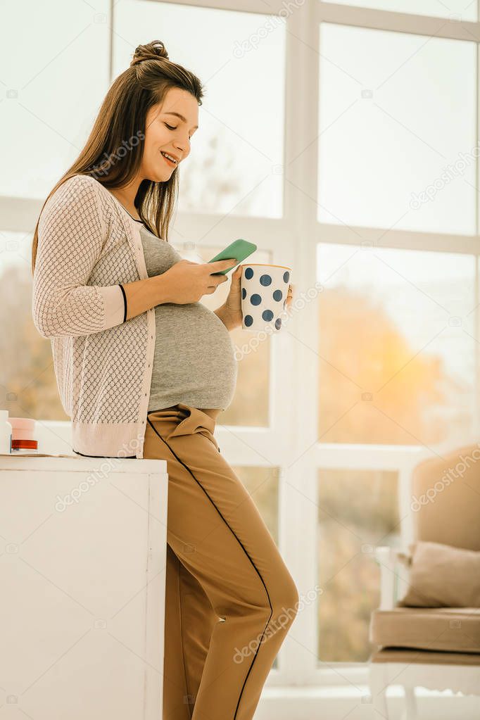 Pregnant woman staying in touch with her friends online