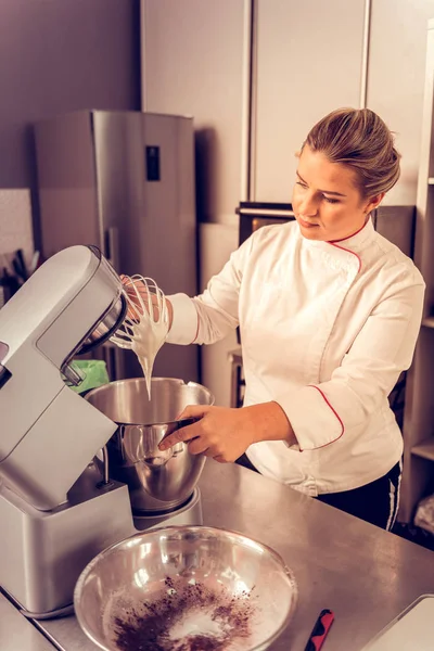 Mulher agradável positivo olhando para a máquina de cozinha — Fotografia de Stock